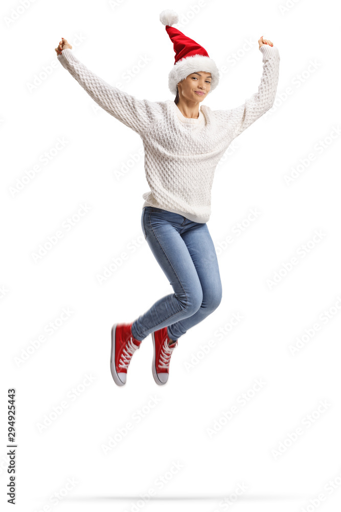 Young woman jumping in the air with a Santa Claus hat