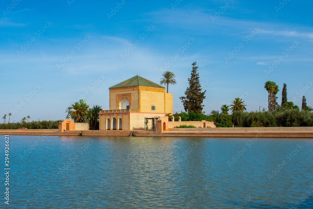 Obraz premium Menara Gardens botanical garden located to the west of Marrakech, Morocco. Pavilon and blue water of basin against atlas mountains 