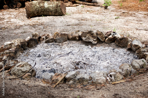 A stone circle fire pit filled with ash from recent fire. photo