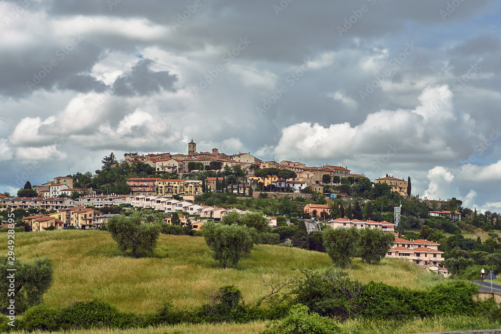 View of the hill with houses and the bell tower of the city of Montanio in Tuscany.