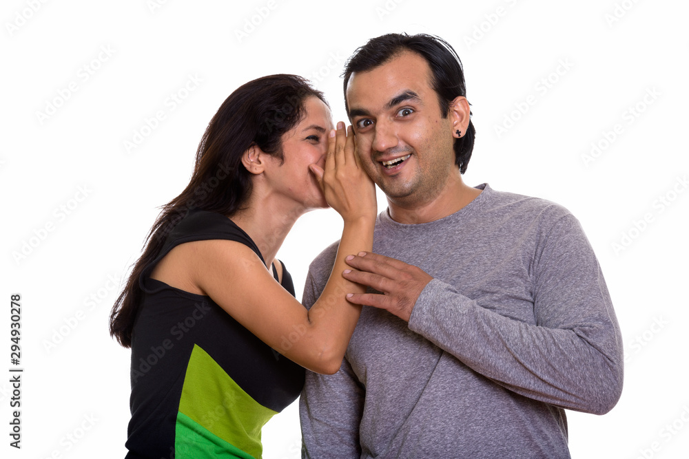Naklejka premium Happy Persian couple smiling while woman whispering to man