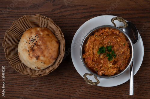 Turkish meze, acili ezme or spicy paste with bread isolated on wooden background photo