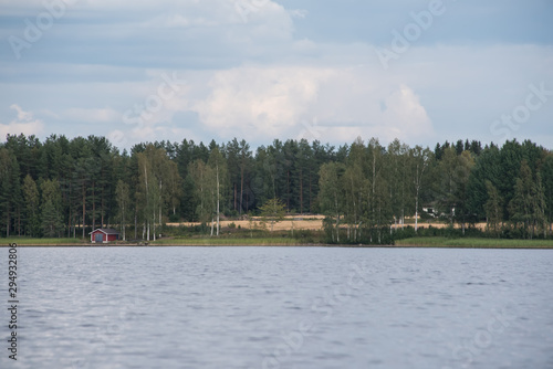 Lake Hallanlahti summer view with reflection of clouds on water .