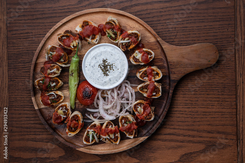 Turkish Beyti kebab served with grilled vegetables and yoghurt sauce isolated on wooden table photo