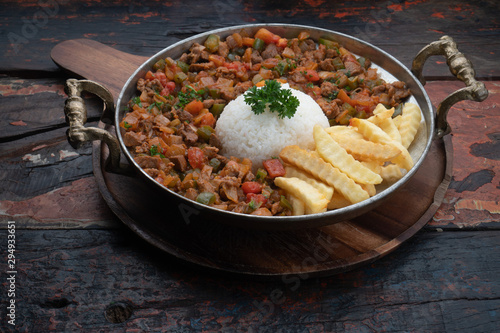 Turkish food lamb meat saute, sac kavurma with rice and french fries isolated on rustic wooden table photo