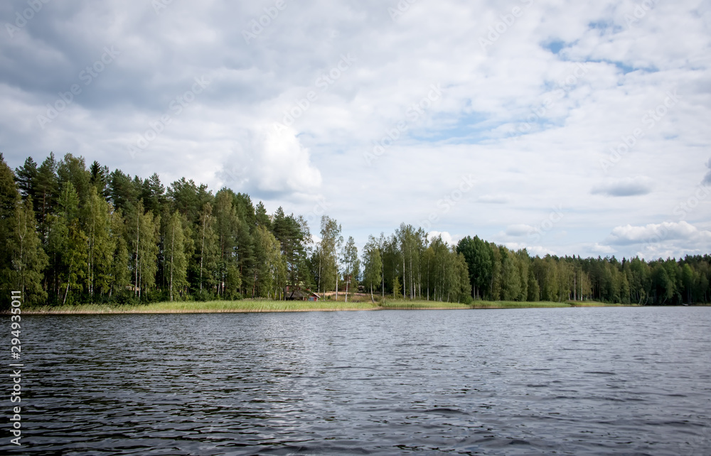 Summer view of the lake Hallanlahti with reflection of clouds on the surface of the water . Finland .