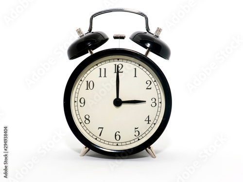 Old-style alarm clock, black and white, it's three o'clock.