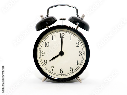 Old-style alarm clock, black and white, it's eight o'clock.