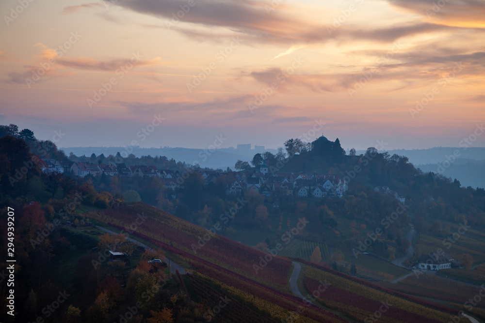 Panoramic view of Stuttgart in autumn. The vineyards' leafs are colorful changing from yellow to red, while the sun is setting above the Neckar valley.