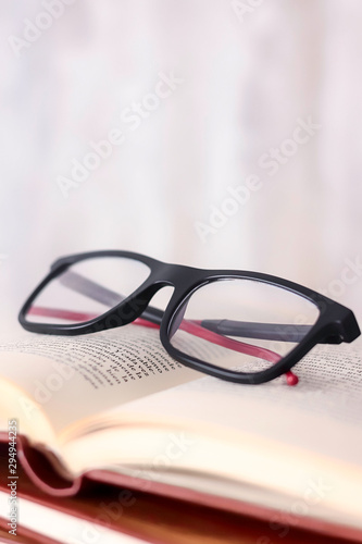 READING GLASSES ON OPEN BOOK.