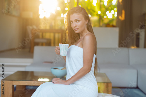 Young sexy girl in the morning in a towel with a cup of tea