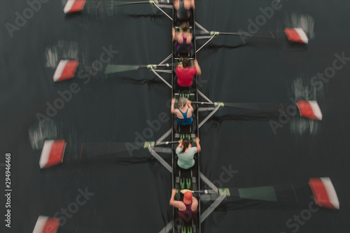Blurred motion overhead view of a rowing crew in a sculling boat on the water, mid stroke,Lake Union
