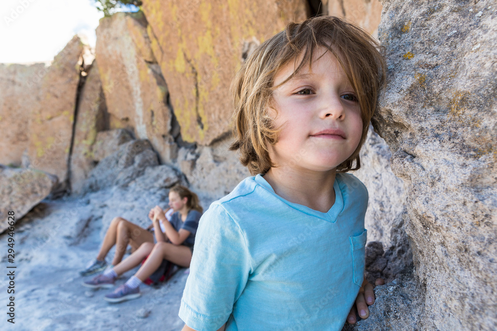 Boy standing at Tsankawi with parents in background Boy standing at Tsankawi with parents in background