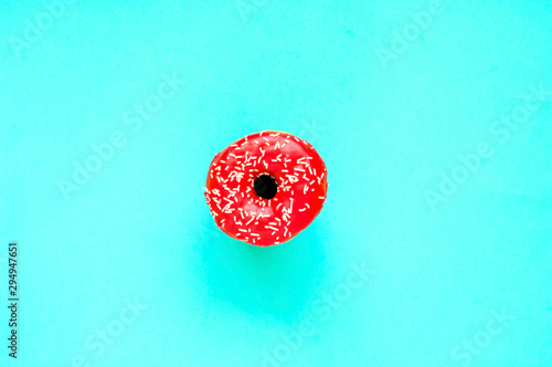 Berry donut with colorful sprinkles on mint background. Concept colorful breakfast. Copy space