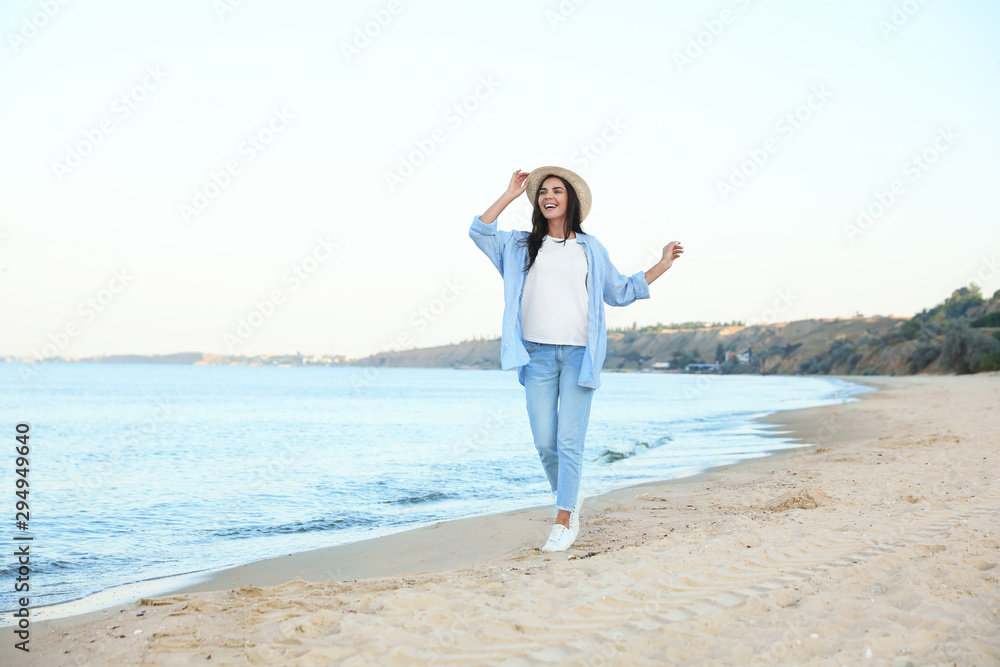 Beautiful young woman in casual outfit on beach