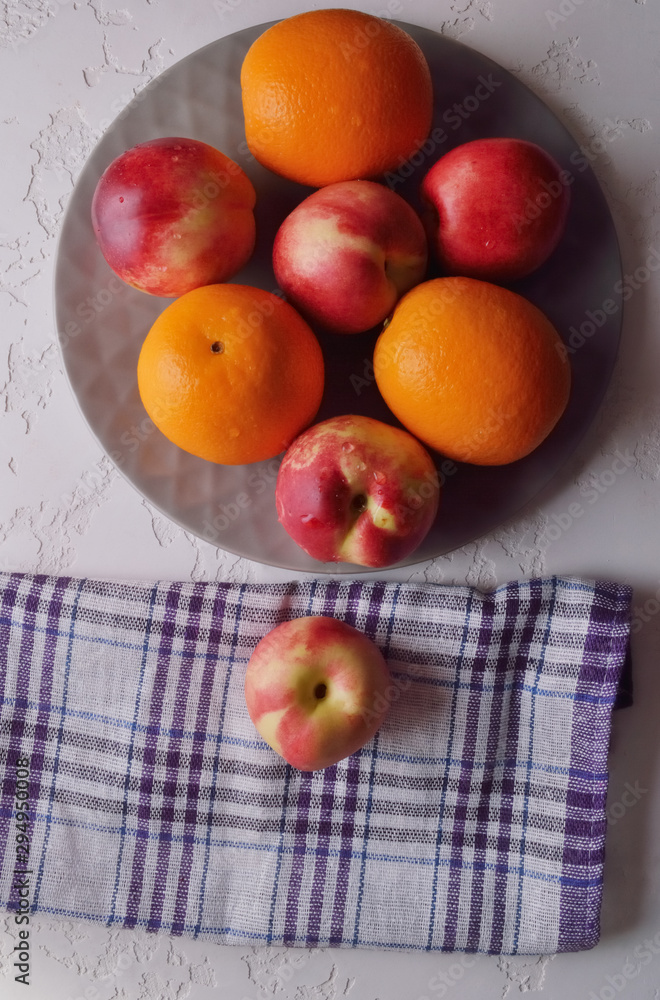 Three Fresh Ripe Nectarine Whole Fruits on grey Plate.Mix of fruits, good harvest. Three Fresh Ripe Nectarine Whole Fruits on grey Plate.Mix of fruits, good harvest.