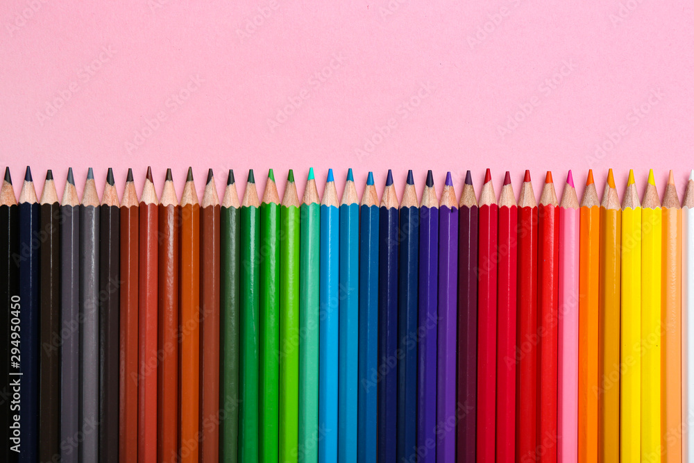 Color pencils on pink background, flat lay. Space for text Color pencils on pink background, flat lay. Space for text