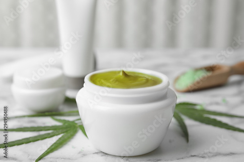Jar of hemp cream on marble table. Organic cosmetics