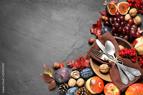 Flat lay composition with cutlery, autumn vegetables and fruits on grey background, space for text. Happy Thanksgiving day