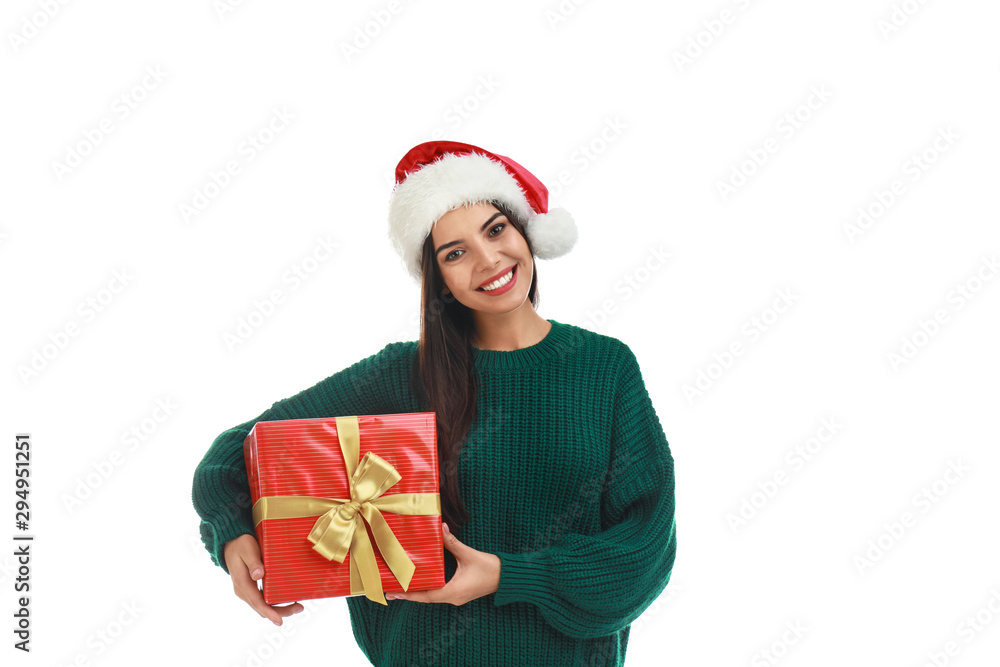 Happy young woman in Santa hat with Christmas gift on white background Happy young woman in Santa hat with Christmas gift on white background