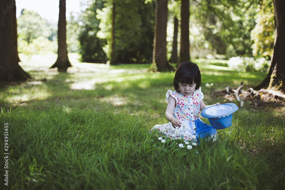 toddler girl playing in summer forest park toddler girl playing in summer forest park