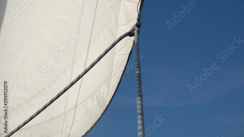 White sail sways on a yacht from the wind. Slow motion