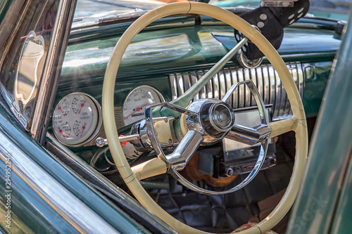 White steering wheel and dashboard of an old timer car.