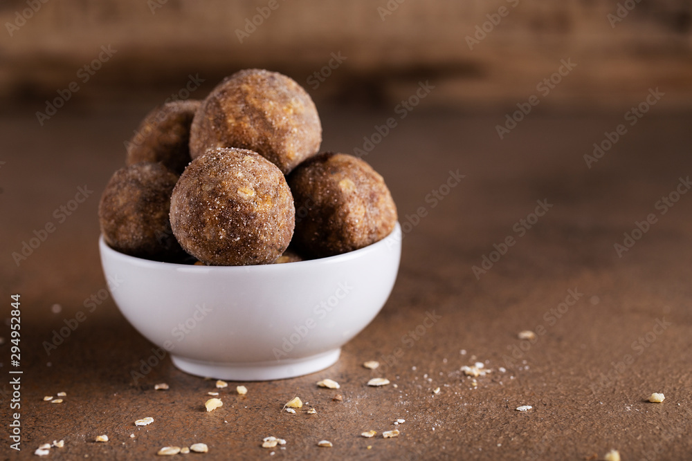 energy balls in a white Cup on a brown table peanut butter dates walnuts oatmeal energy balls in a white Cup on a brown table peanut butter dates walnuts oatmeal
