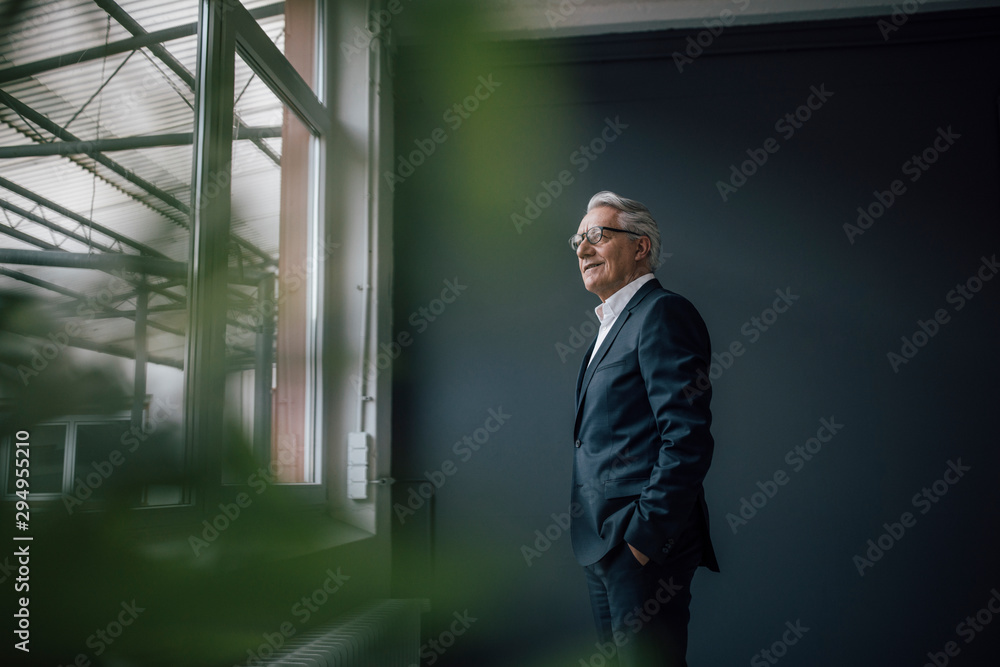 © Westend61 - Senior businessman looking through window © Westend61 - Senior businessman looking through window