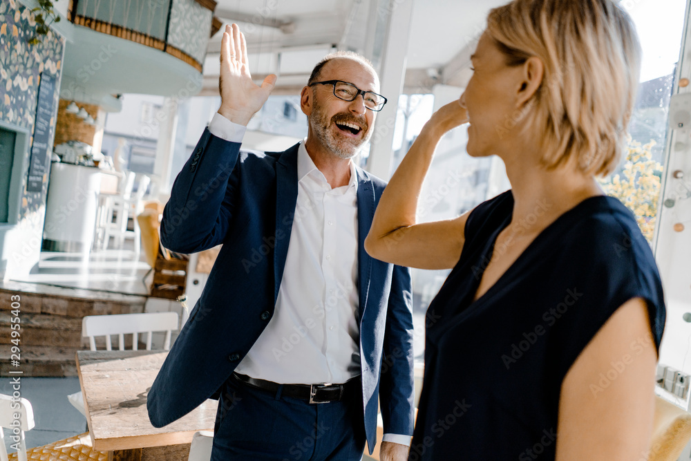 Business people high fiving in a coffee shop Business people high fiving in a coffee shop