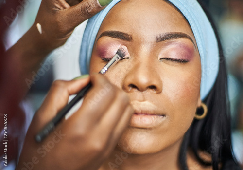 Close up of visagiste applying eyeshadow on woman