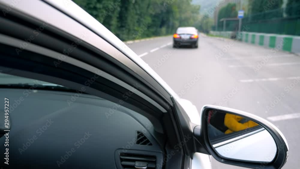side rear-view mirror of a car while driving on a highway. side rear-view mirror of a car while driving on a highway.