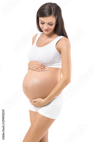 Pregnancy. Young, pregnant woman, on isolated white background holding belly.