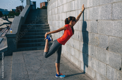 Young sporty woman doing stretching in city. Sport girl