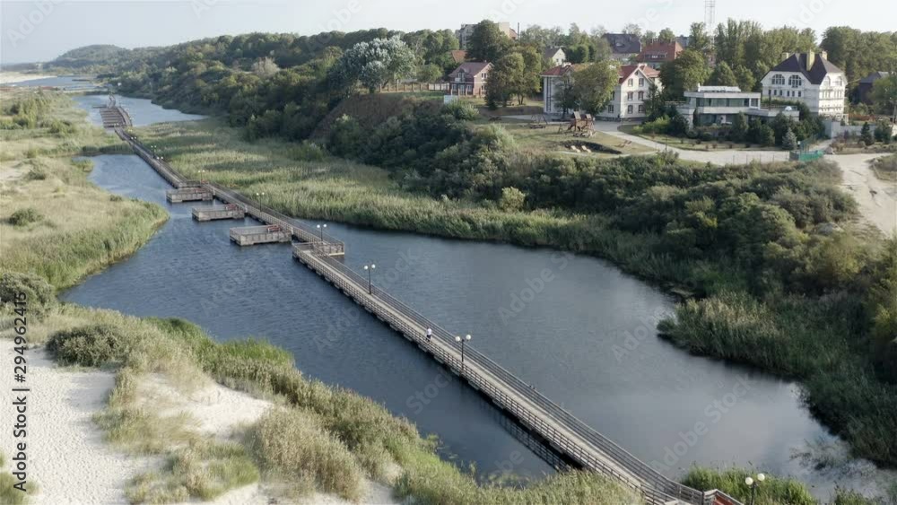 a tourist walks on a floating wooden pontoon near the coastal zone. a tourist walks on a floating wooden pontoon near the coastal zone.