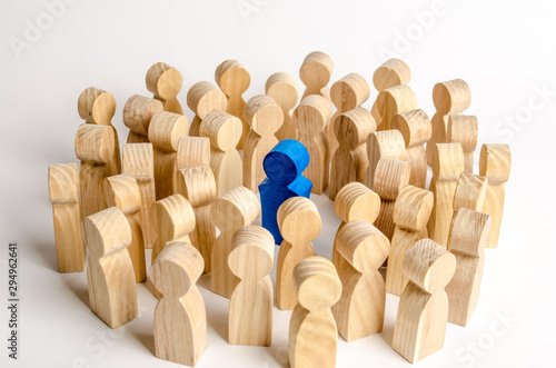 The blue figure of the leader is surrounded by a crowd of people. Leadership and team management, an example for imitation. Loyalty and trust. Idol. Like-minded people and followers