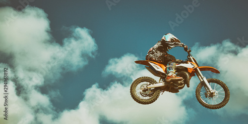 Motorcyclist isolated on blue sky background. Extreme concept, long jump on a motorcycle.