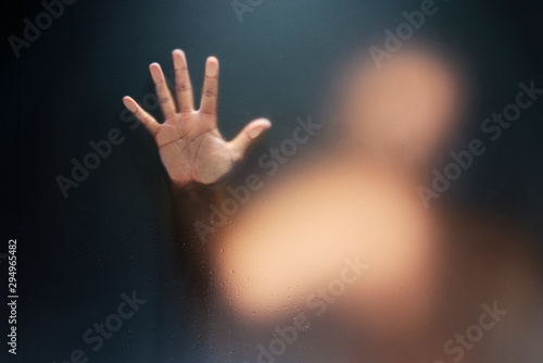 Creepy man holding the frosted glass with one hand. © ardasavasciogullari