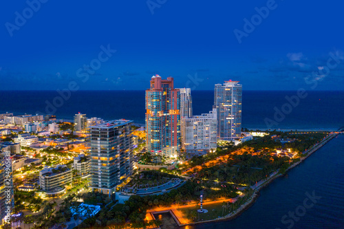 Aerial night photo Miami Beach condominiums illuminated South Pointe Park scene