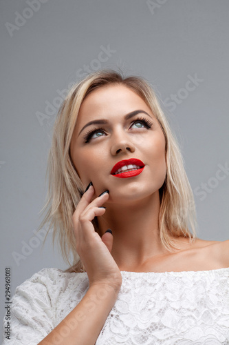 Attractive woman with red lips. Blonde girl in white clothes.