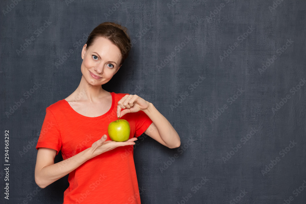 Portrait of happy girl holding ripe yellow-green apple in hands Portrait of happy girl holding ripe yellow-green apple in hands