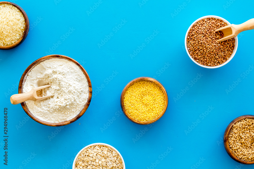 Healthy food. Cereals - rice, oats, buckwheat - in bowls on blue background top view Healthy food. Cereals - rice, oats, buckwheat - in bowls on blue background top view