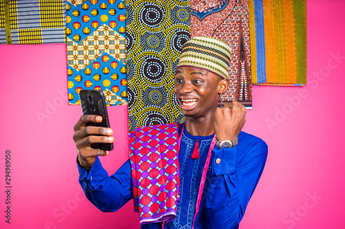 a youn nigerian tailor feels very shocked with what he saw on his phone photo