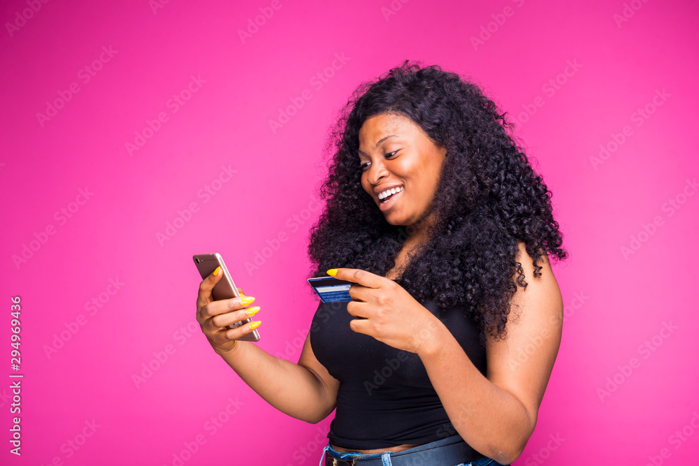 a beautiful young african nigerian lady feels happy what she is doing with her smart phone and credit card a beautiful young african nigerian lady feels happy what she is doing with her smart phone and credit card