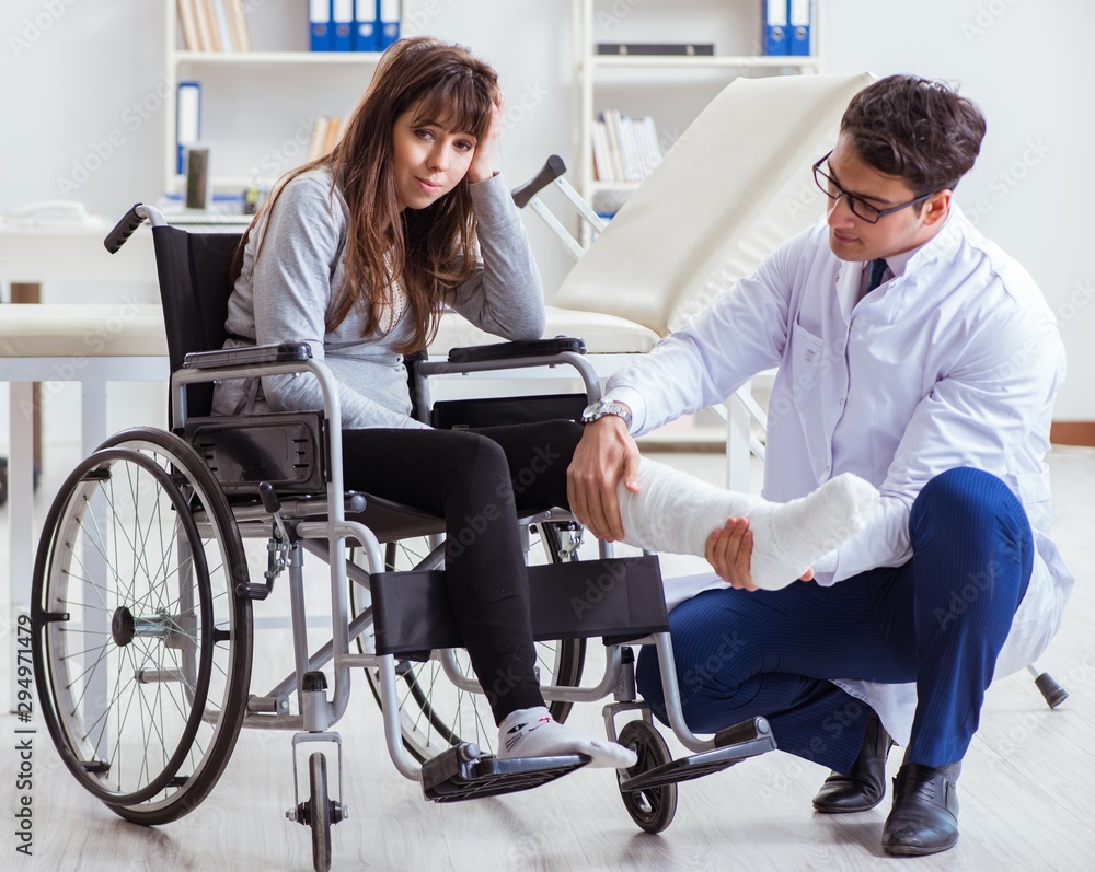 Male doctor examining female patient on wheelchair Male doctor examining female patient on wheelchair