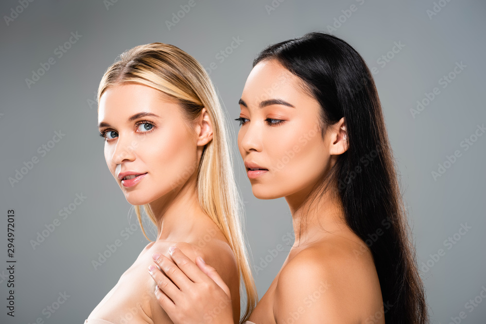 side view of beautiful european blonde and asian brunette naked women isolated on grey side view of beautiful european blonde and asian brunette naked women isolated on grey