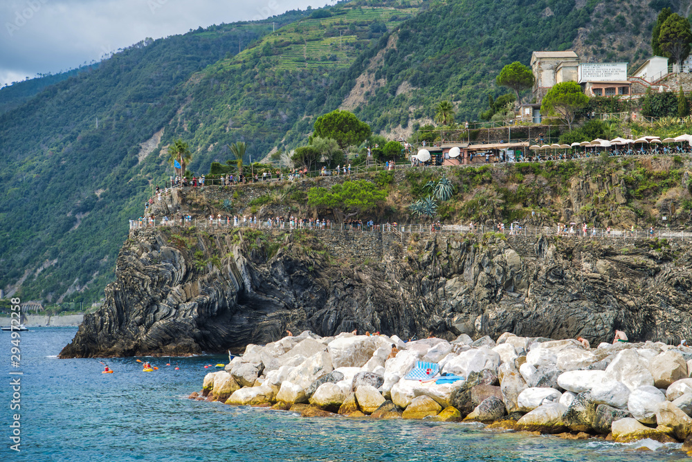 Cinque Terre, Italy - August 17, 2019: Boat trip along the Ligurian coast. Mountain landscape with residential buildings. Nature trail in the Italian Riviera