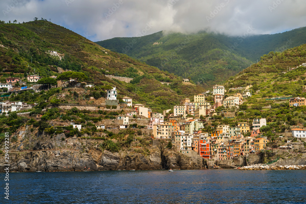 Riomaggiore, Cinque Terre, Italy - August 17, 2019: Village by the sea bay, colorful houses on the rocky coast. Nature reserve resort popular in Europe.