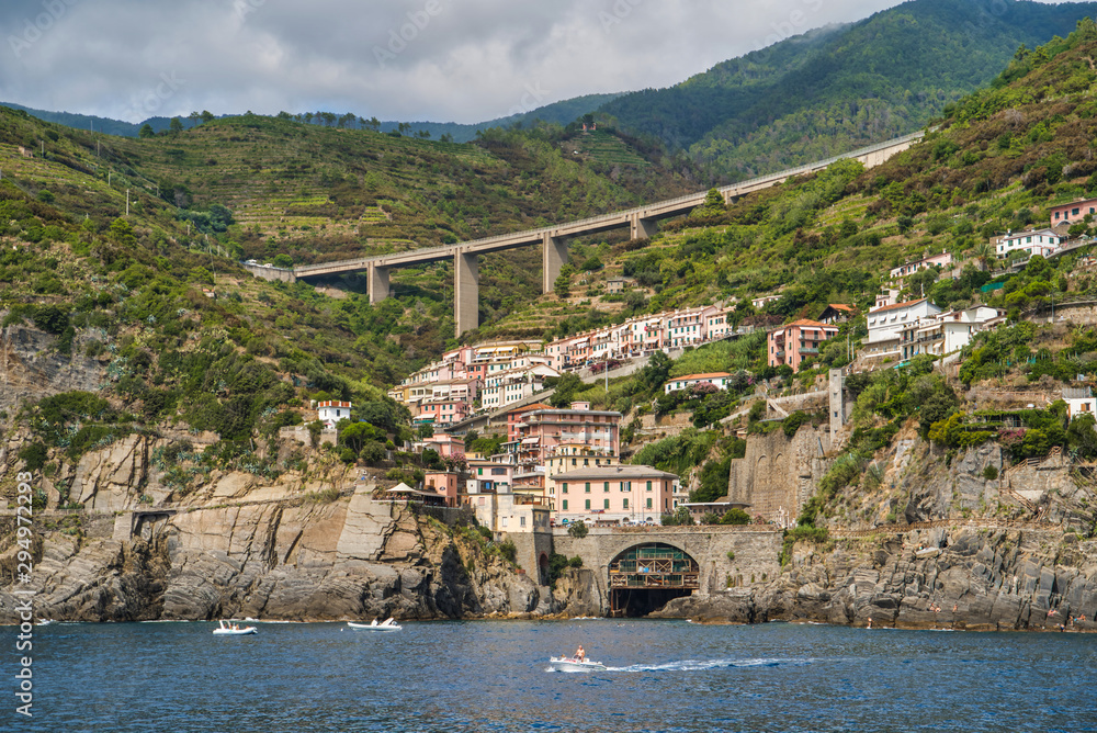 Riomaggiore, Cinque Terre, Italy - August 17, 2019: Village by the sea bay, colorful houses on the rocky coast. Nature reserve resort popular in Europe. Small beach