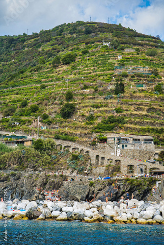 Cinque Terre, Italy - August 17, 2019: Boat trip along the Ligurian coast. Mountain landscape with residential buildings.